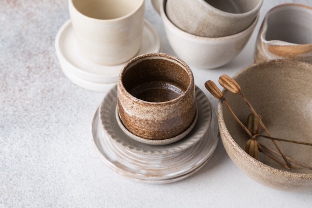 Set of ceramic tableware. Empty craft ceramic plates, bowls, and cups.