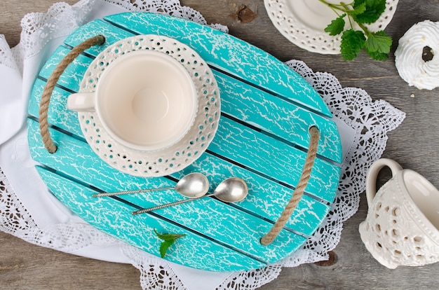 Set of ceramic tableware on a wooden tray. Kitchen interior