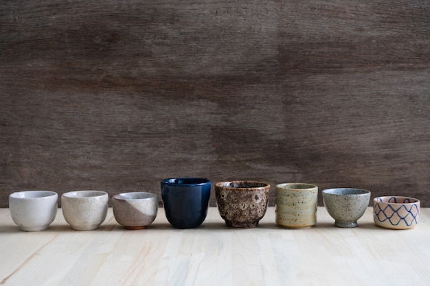 Photo set of ceramic tea cup on wooden background.