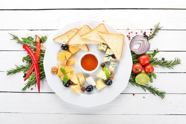 A set of cheeses on a plate. On a wooden background. Top view. Copy space.