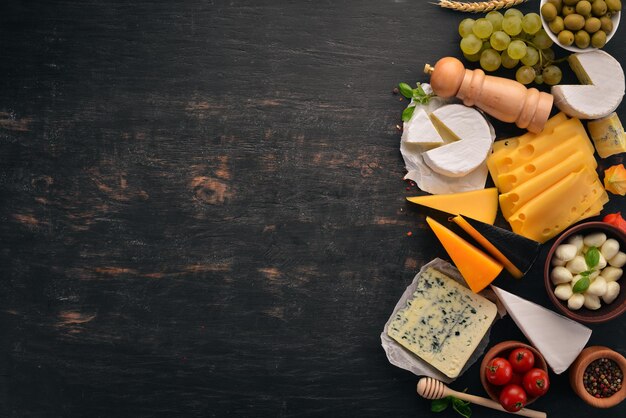 Set cheeses suluguni blue cheese mozzarella maasdam brie cheese
top view on a black wooden background free copy space