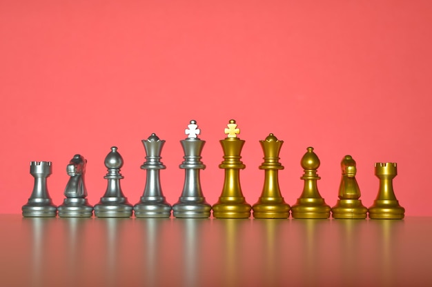 Set of chess figures in a row isolated on a red background