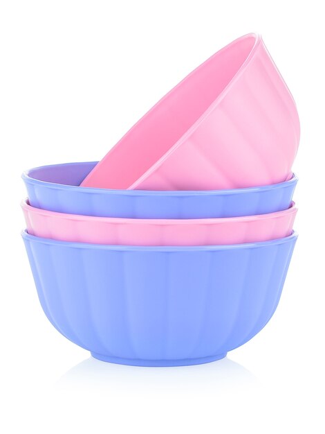 Set of children's plastic tableware of different colors on a white background.