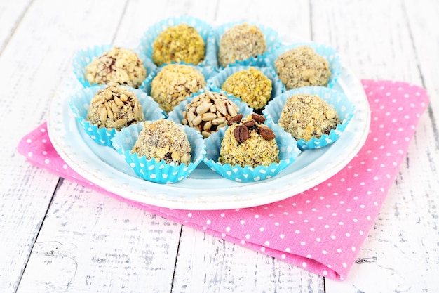 Set of chocolate candies, on plate, on wooden background