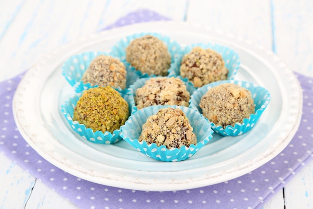 Set of chocolate candies, on plate, on wooden background