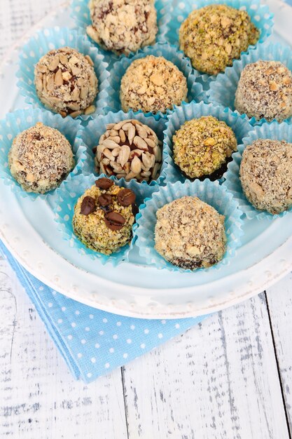 Set of chocolate candies, on plate, on wooden background