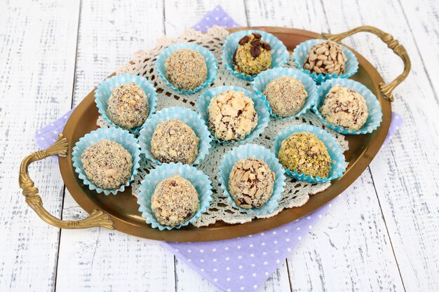 Set of chocolate candies, on tray, on color wooden background