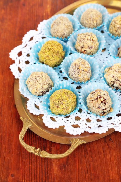 Set of chocolate candies, on tray, on wooden background