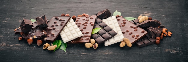 Set of chocolate with nuts cookies and cocoa On a black wooden background Top view Copy space for text