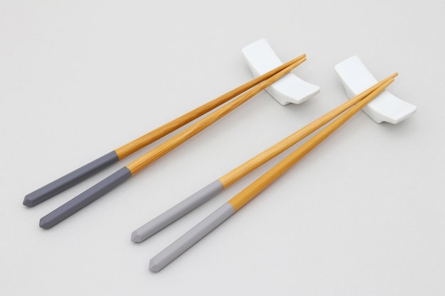 A set of chopsticks with a grey and yellow handle.