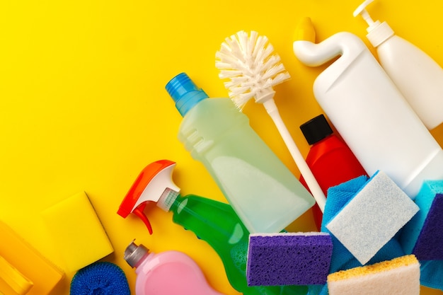 Photo set of cleaning supplies on yellow color background