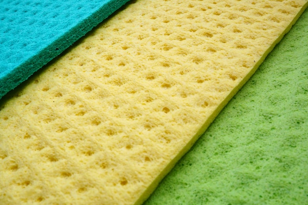 Photo a set of cleaning wipes microfiber cloths or sponges for the kitchen three multicolored cloths sponge fibers sponge texture pattern surface closeup background green blue and yellow