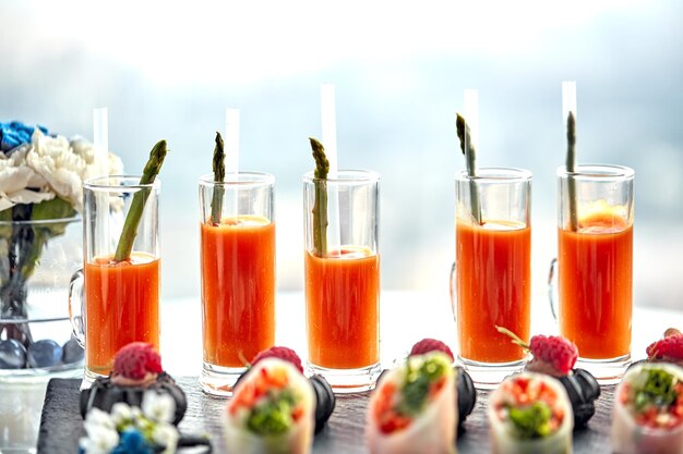 Set cocktails gemaakt van wortelsap en asperges Gezond eten een momentopname van verschillende wortelen en asperges die op een tafel staan