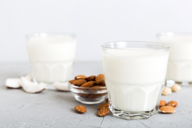 Set or collection of various vegan milk almond coconut cashew on table background Vegan plant based milk and ingredients top view