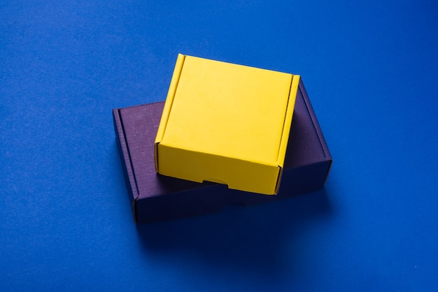 Set of color cardboard boxes on blue background, top view