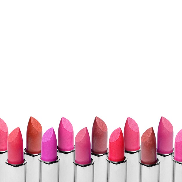 Set of color lipsticks arranged in line isolated on white surface