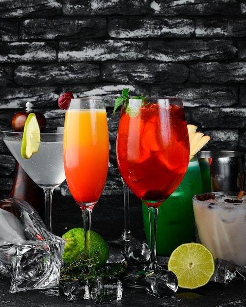 Набор цветных алкогольных коктейлей на черном баре