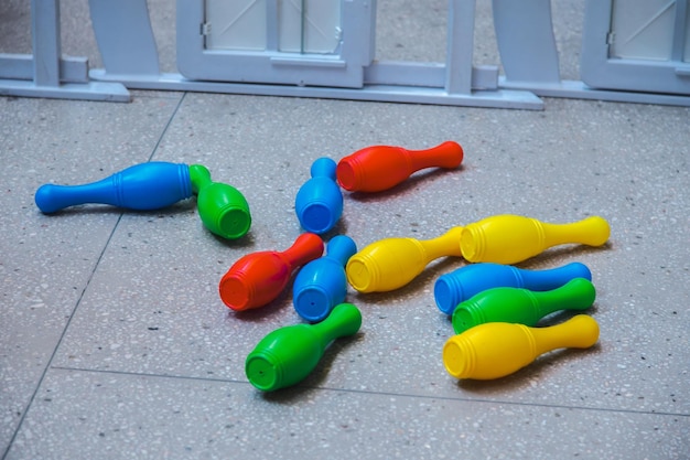 床に落ちたカラフルなプラスチックのおもちゃのボウリングピンのセット