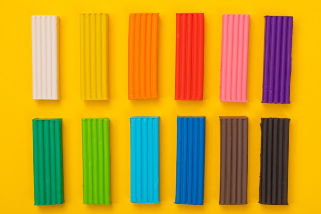 Set of colorful plasticine isolated on yellow background