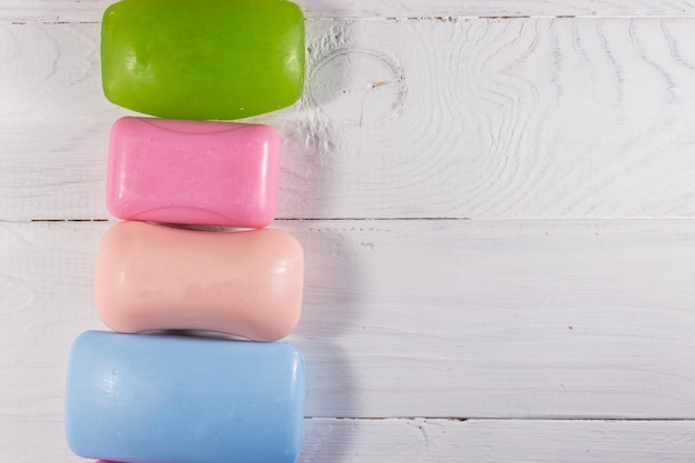 Set of colorful soap on white wooden background