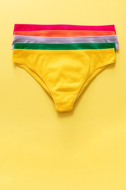 Set of colorful underpants on yellow background close up