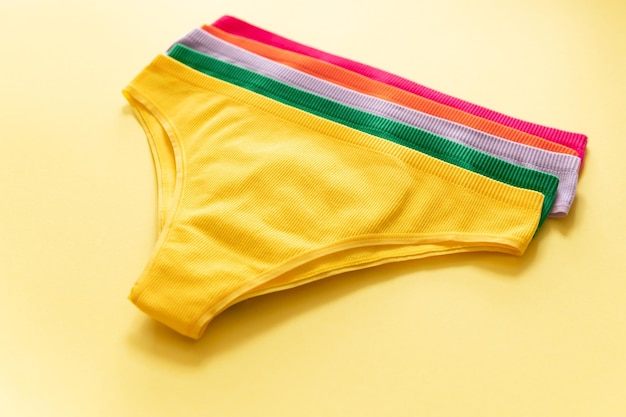 Photo set of colorful underpants on yellow background close up