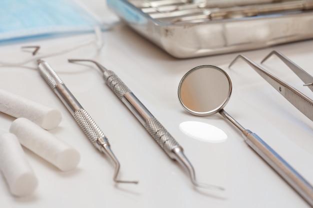 Set of composite filling instruments for dental treatment. Medical tools and protective mask. Close-up view. Shallow depth of field.