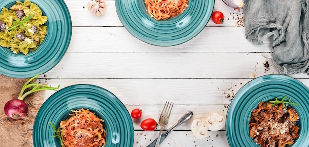 Foto un set di paste cotte in piatti su uno sfondo di legno cucina italiana vista dall'alto copia spazio