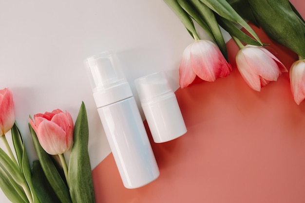 Set of cosmetic care products on a white background and tulips