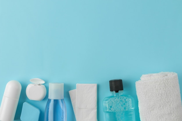 A set of cosmetics and personal care products for traveling on a gentle light blue background. top view. travel cosmetics