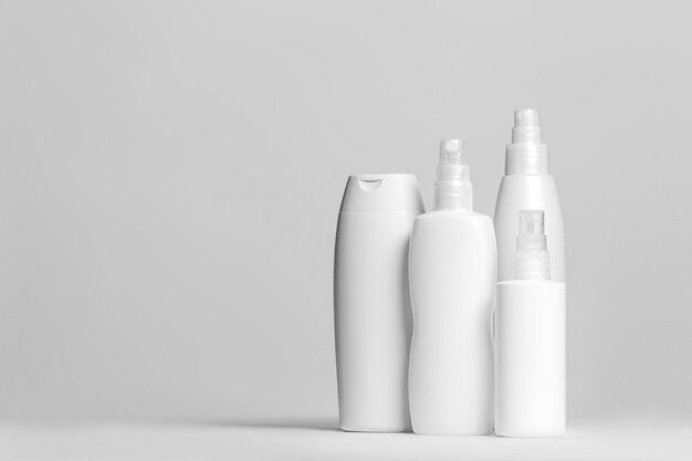 Set cosmetische producten in witte en grijze containers op lichte achtergrond