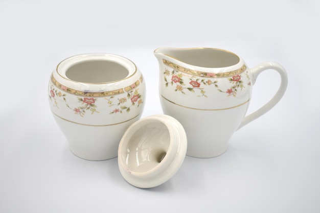 A set of creamer and creamer sets with a small bowl on the left.