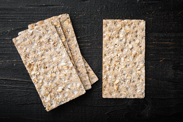 Set of crispy breads set, on black wooden table background, top view flat lay