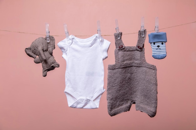 a set of cute newborn baby clothes and toys hanging on a line