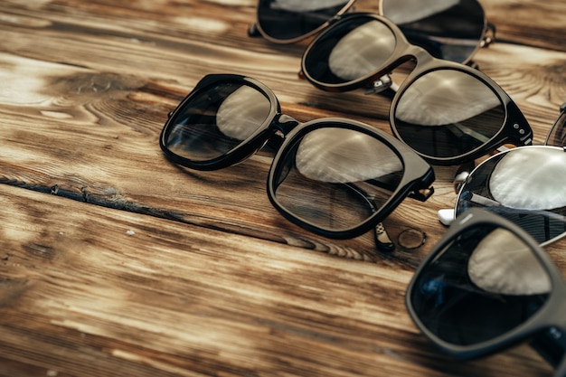 Set of dark sunglasses on grunge brown wooden surface