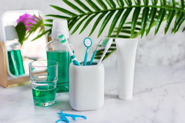 Set of dental hygiene products on white marble table in a bathroom Teeth care products