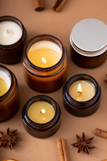 Un set di diverse candele aromatiche in vasetti di vetro su sfondo bianco candela profumata fatta a mano le candele di soia stanno bruciando in un barattolocera e paraffina in un barattolo