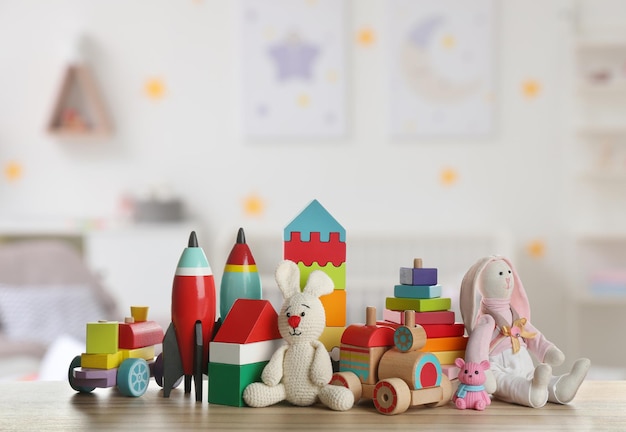 Set of different cute toys on wooden table in children39s room