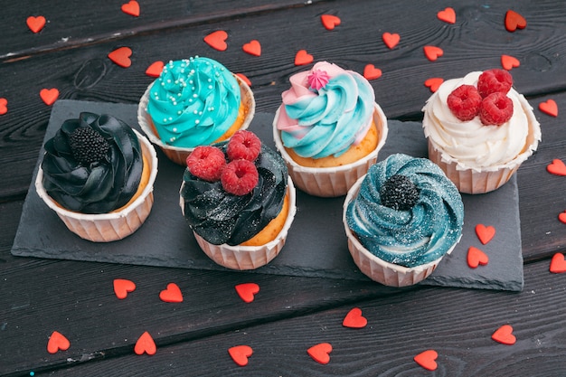 Set of different delicious cupcakes on dark