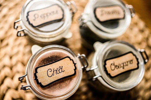 Set of different spicies and peppers in glass jars at the kitchen