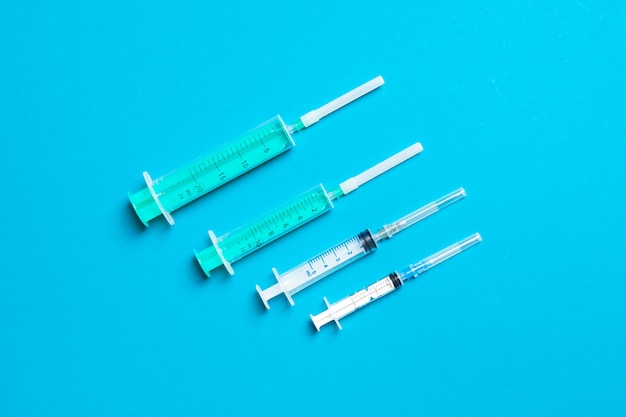 Set of different syringes on a colored background