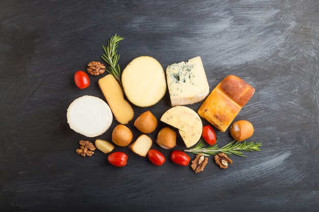 Set of different types of cheese on a black wooden background