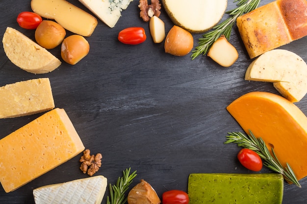 Set of different types of cheese with rosemary and tomatoes