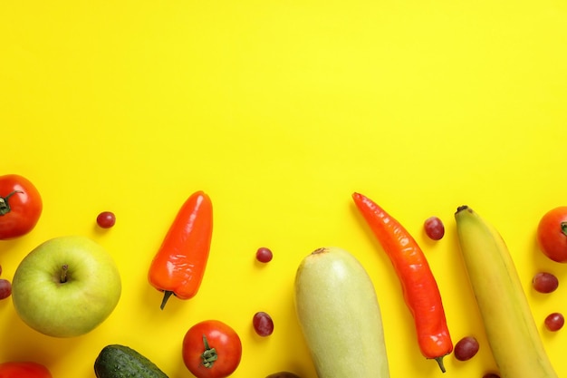 Set of different vegetables and fruits on yellow background