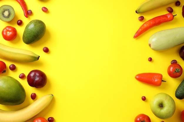 Set of different vegetables and fruits on yellow background