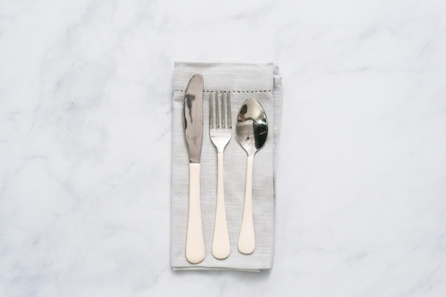 Set of dining silverware on linen dinner napkin.