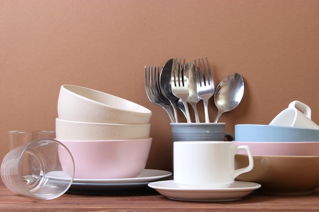 A set of dishes and kitchen utensils on a colored background