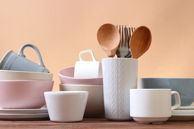 A set of dishes and kitchen utensils on a colored background