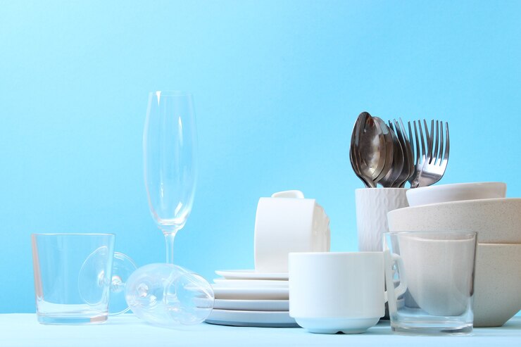 Photo a set of dishes and kitchen utensils on a colored background