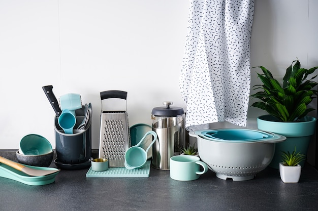 Set of dishes and kitchen utensils on a white wall.